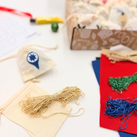 Crafting materials including thread, fabric, and a box on a white surface