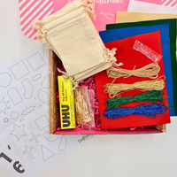 Craft kit with adhesive, ribbons, and other materials on a white surface