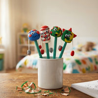 Finished clay monster pencil toppers in a pot on a child's desk